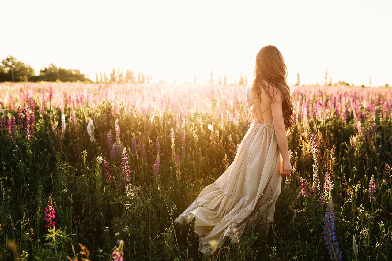 mujer-joven-que-camina-campo-flor-puesta-sol-fondo.jpg