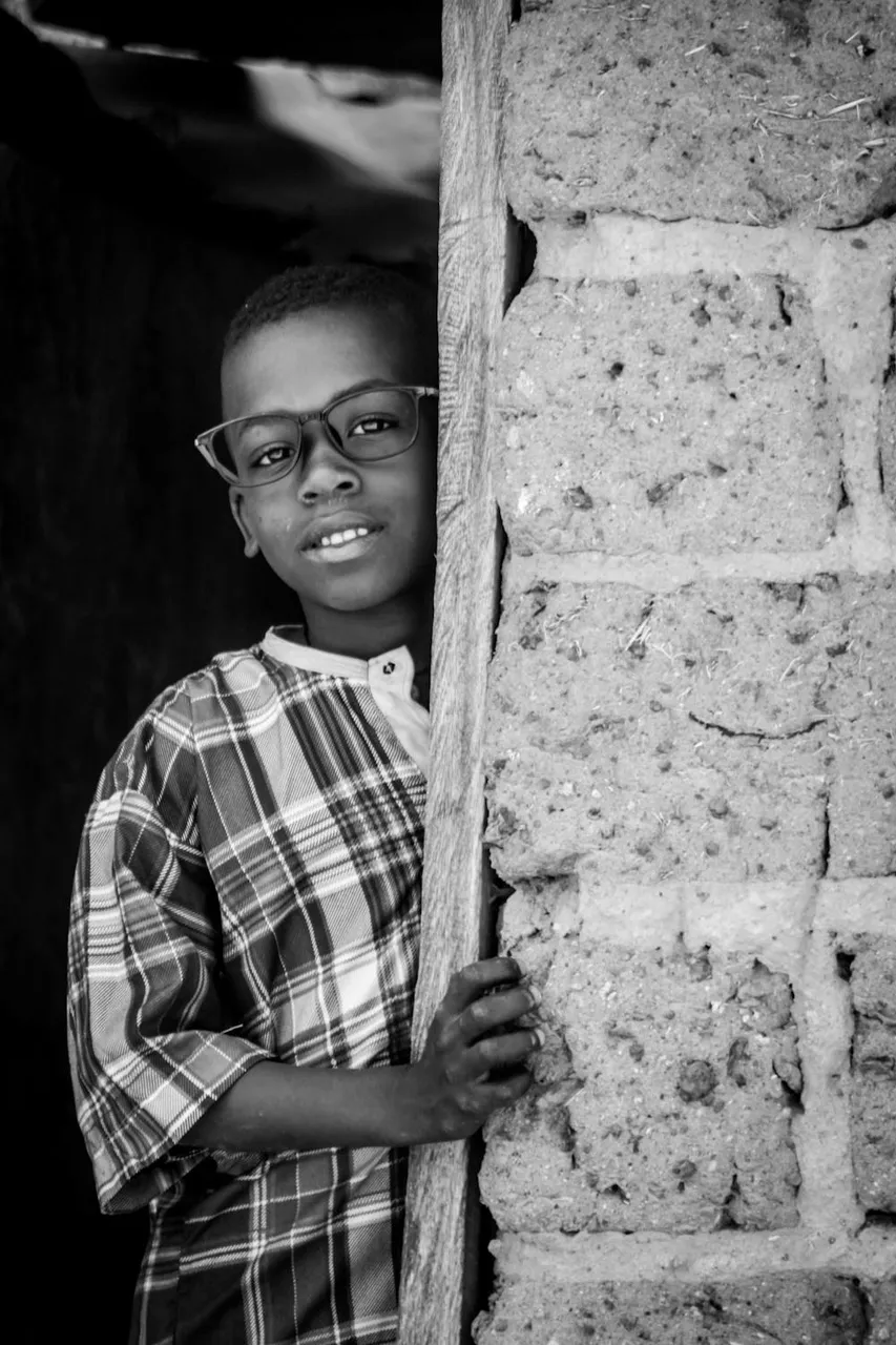 free-photo-of-young-boy-in-glasses-leaning-against-brick-wall.jpeg
