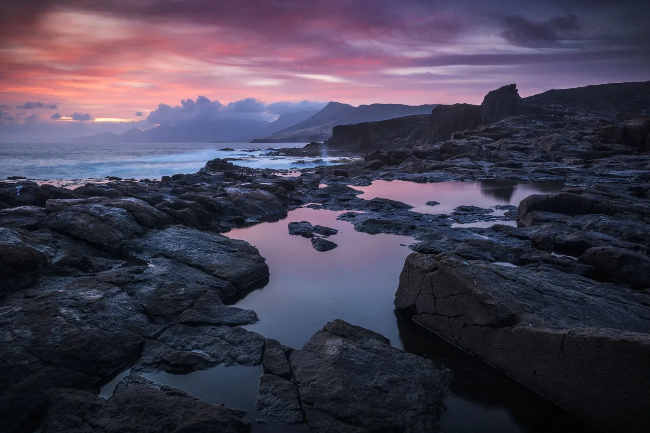 Dark and rugged coastline at Punta Pesebre