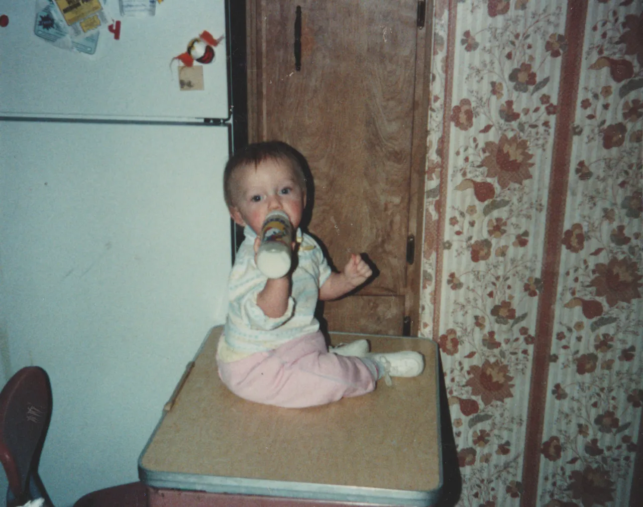 1992 - Crystal drinking a bottle on the Joey dress in the 163 kitchen.png