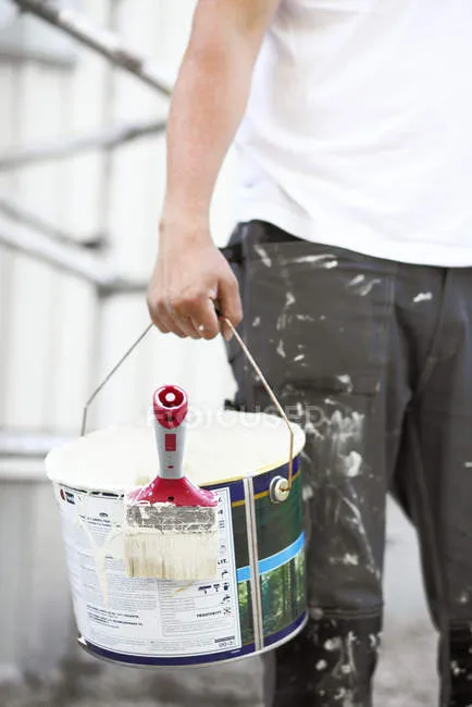 focused_186449484-Man-carrying-bucket-white-paint.jpg