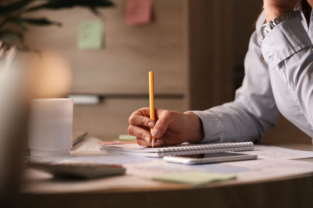 unrecognizable-businesswoman-working-office-writing-business-plans-her-notebook.jpg