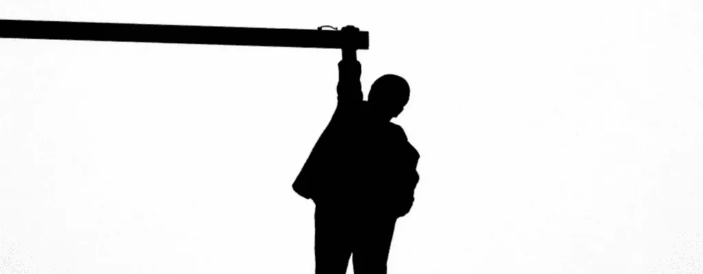 Man dangling from a pole