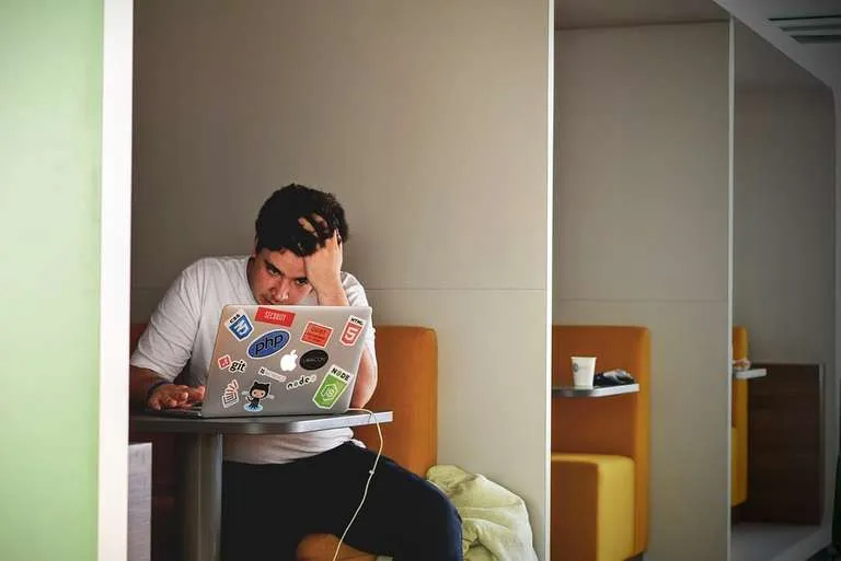 a-frustrated-man-using-the-apple-laptop-in-a-cafe-md.jpg