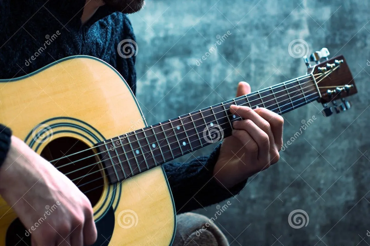 young_man_playing_acoustic_guitar_background_concrete_wall_67871266.jpg