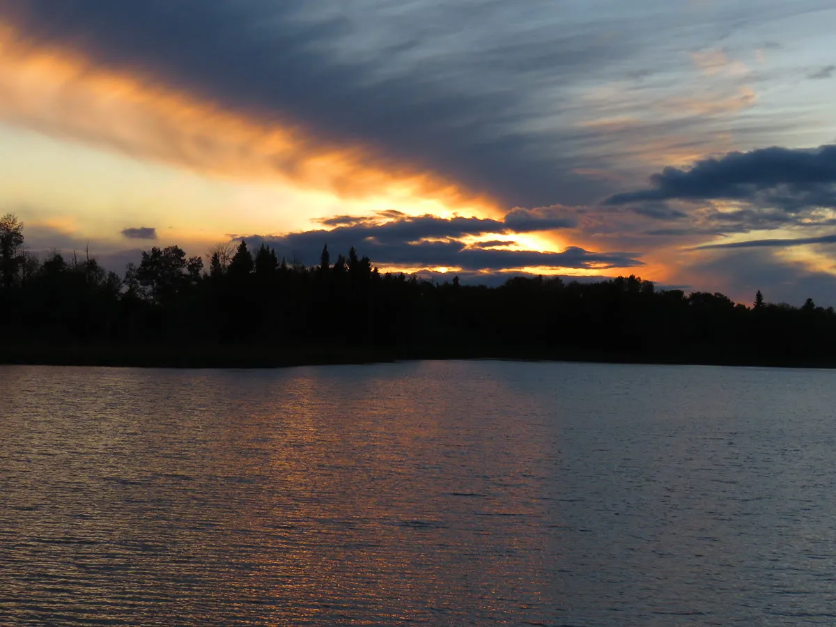 brilliant colors in streaks of clouds over pond.JPG