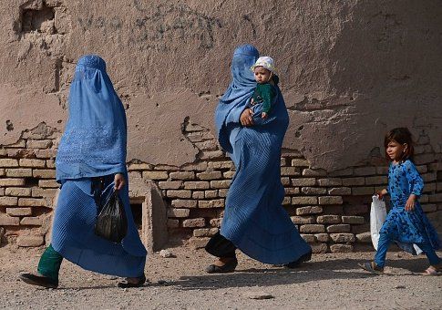 Afghan women walk with their children / Getty Images