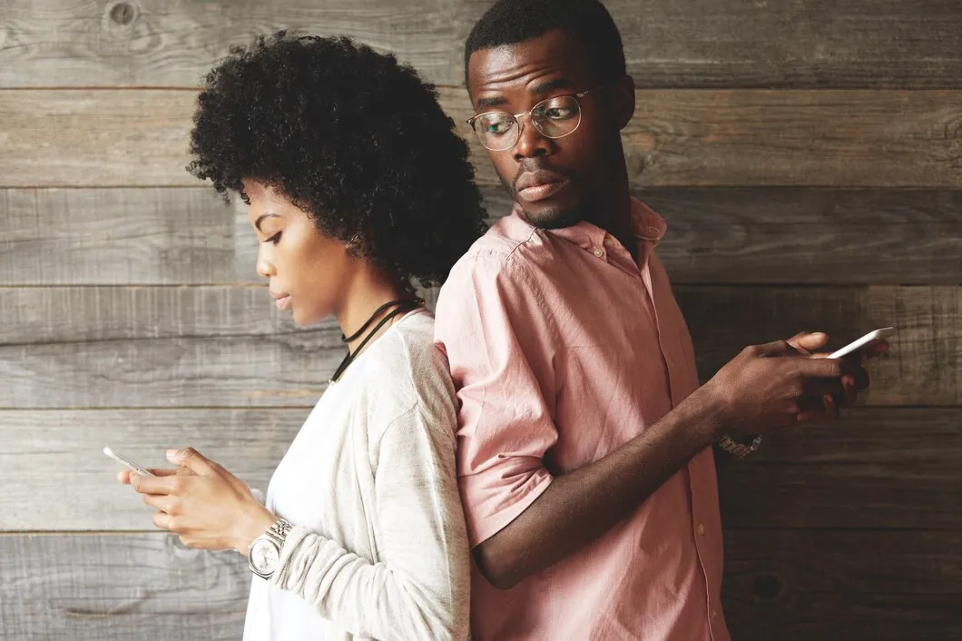 young-african-couple-standing-back-back-holding-mobile-phones_273609-13131.jpg
