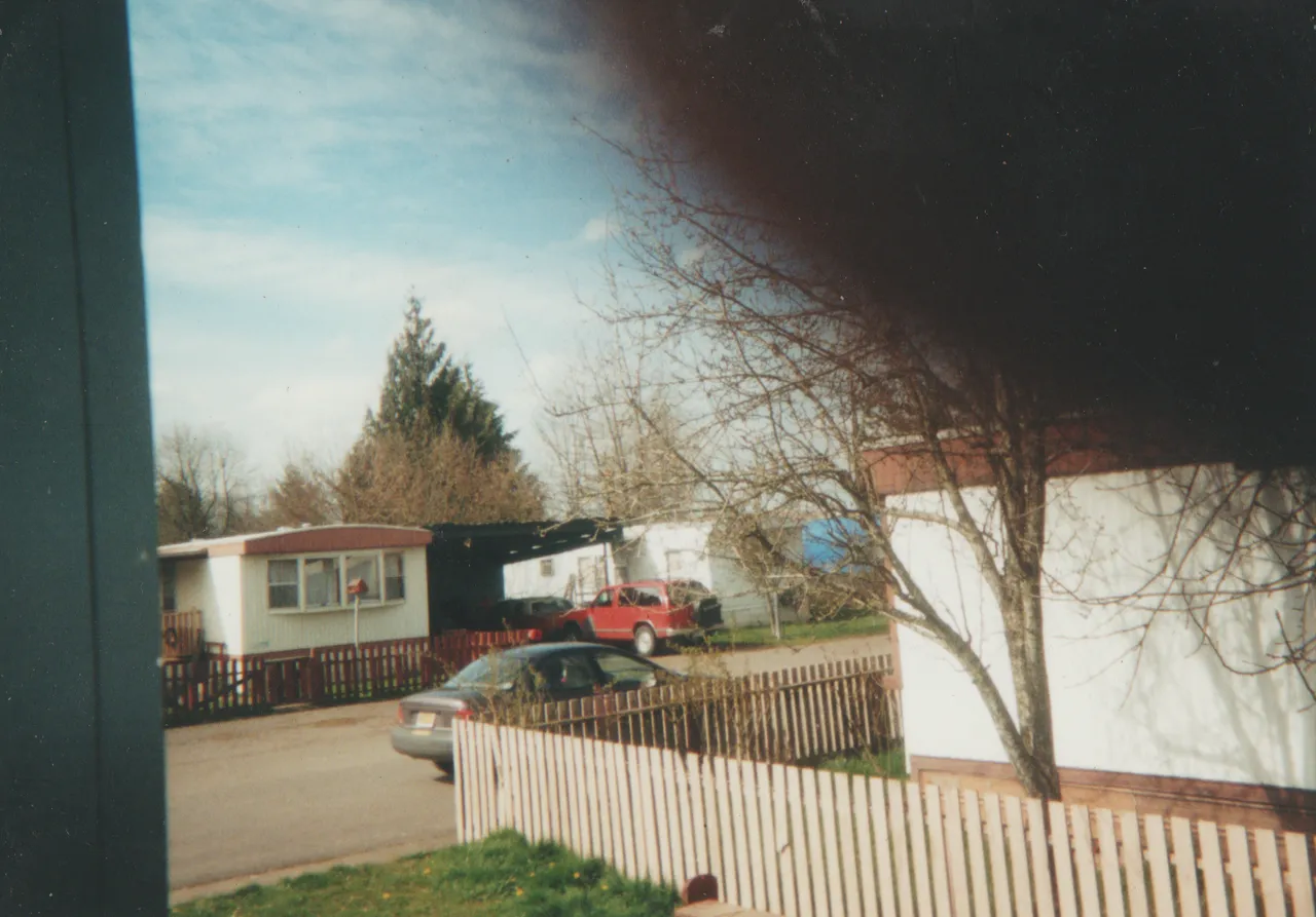1997 - at the 163 front yard from the window towards 164 and the street, not sure what year, the fence.png