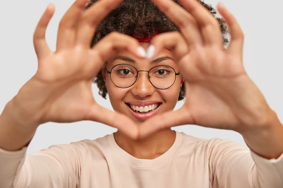photo_attractive_young_woman_makes_heart_shape_gesture_face.jpg