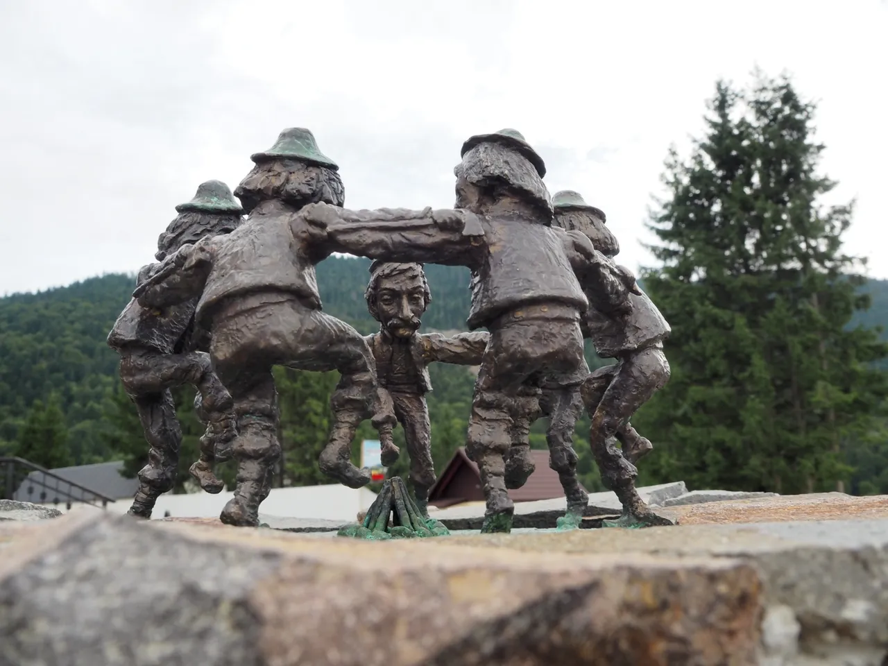 Small sculptures of Hutsul dancing Arkan on the background of mountains