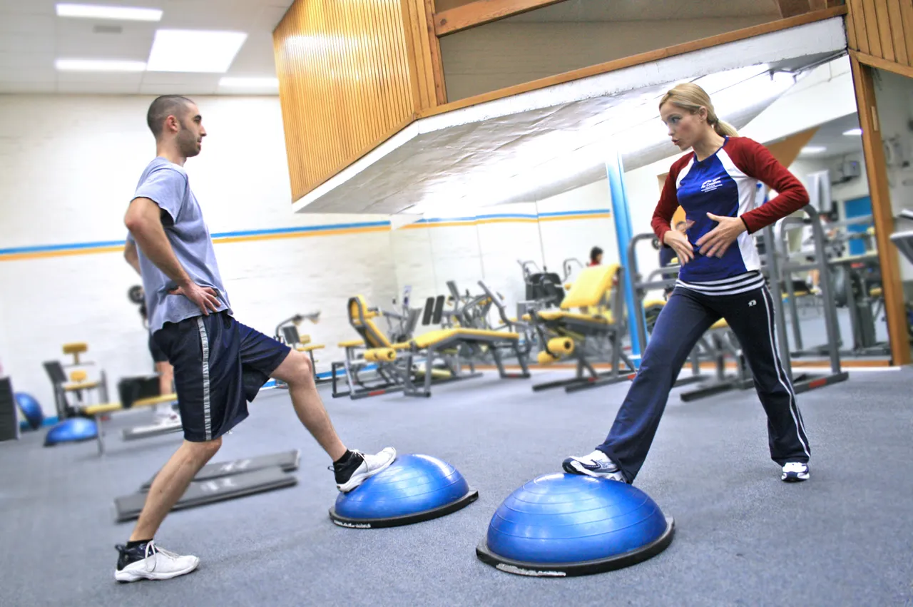 Two_people_in_a_gym_using_BOSU_balls.jpg