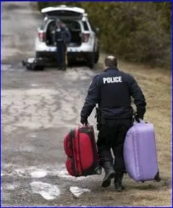 An RCMP officer cares the luggage of an alien who has illegally crossed from the USA into Canada, usually in Quebec at Roxham