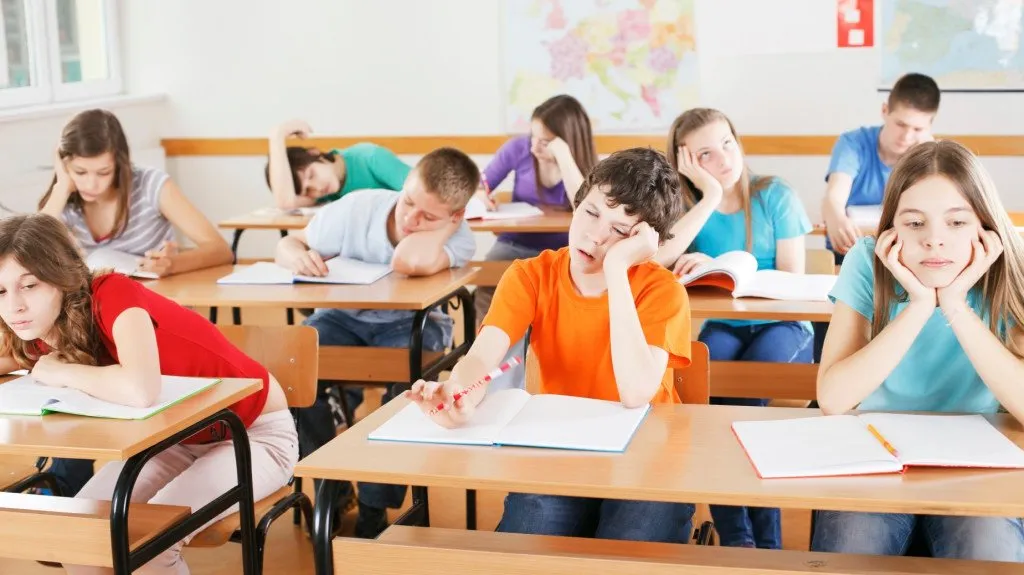 Group of bored pupils in a classroom, during lesson.