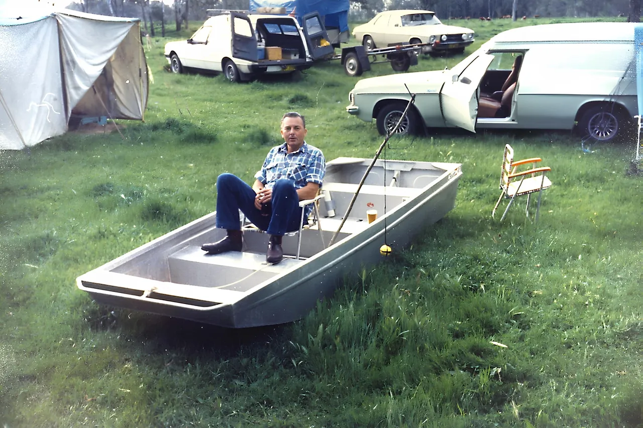 DAD SITTING IN TINNIE ON THE GRASS AT WAGGA .JPG