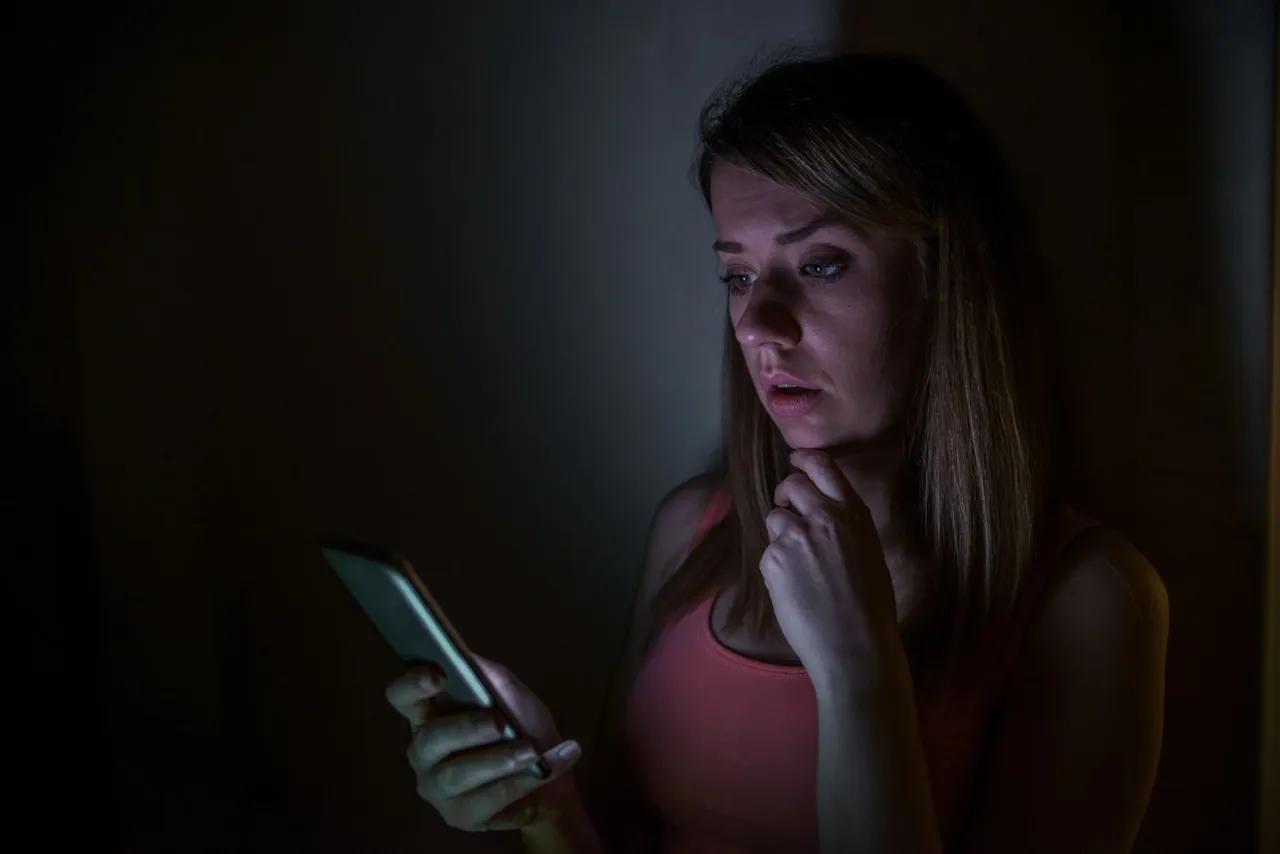 sad-news-upset-young-woman-with-mobile-phone-reads-message-night-portrait-home.jpg