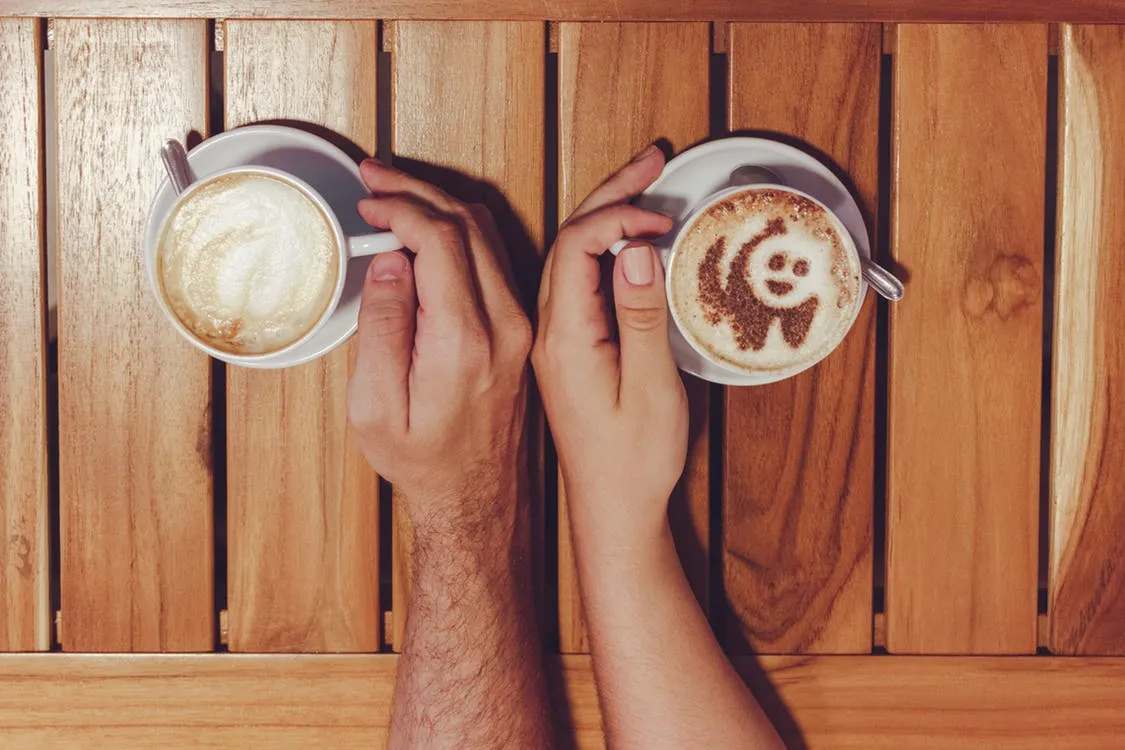 Person Holding Cup of Coffees on Table.jpeg