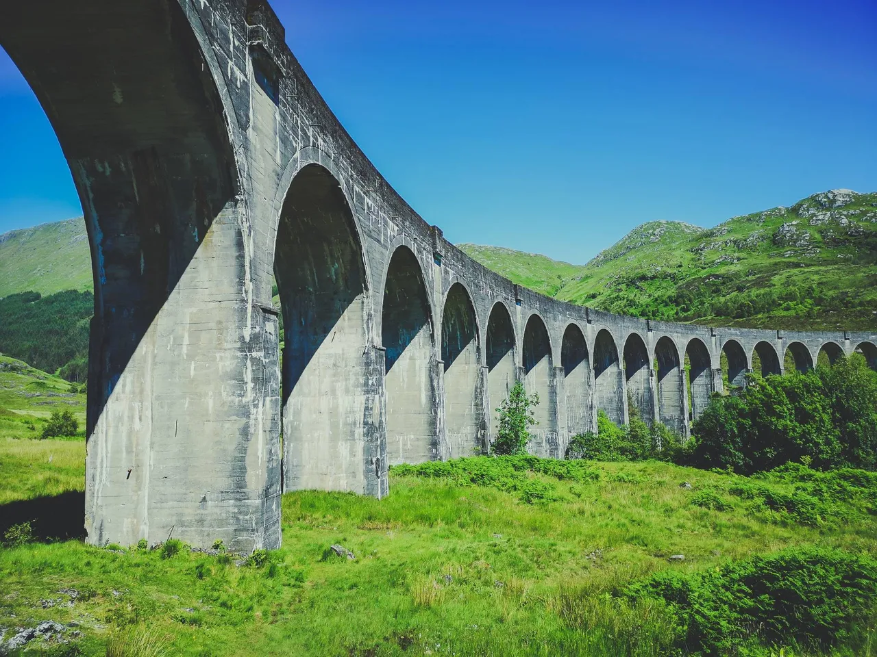 Glenfinnan Viaduct from below on a sunny summer day, Scotland. Photo by Alis Monte [CC BY-SA 4.0], via Connecting the Dots
