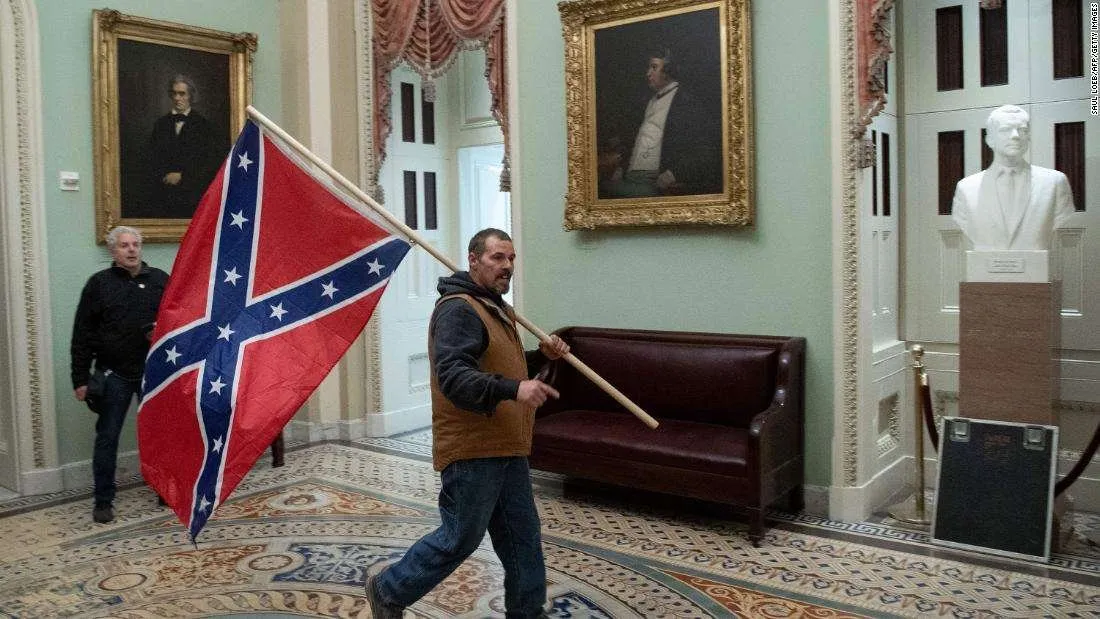 Man carrying confederate flag past the Senate chamber