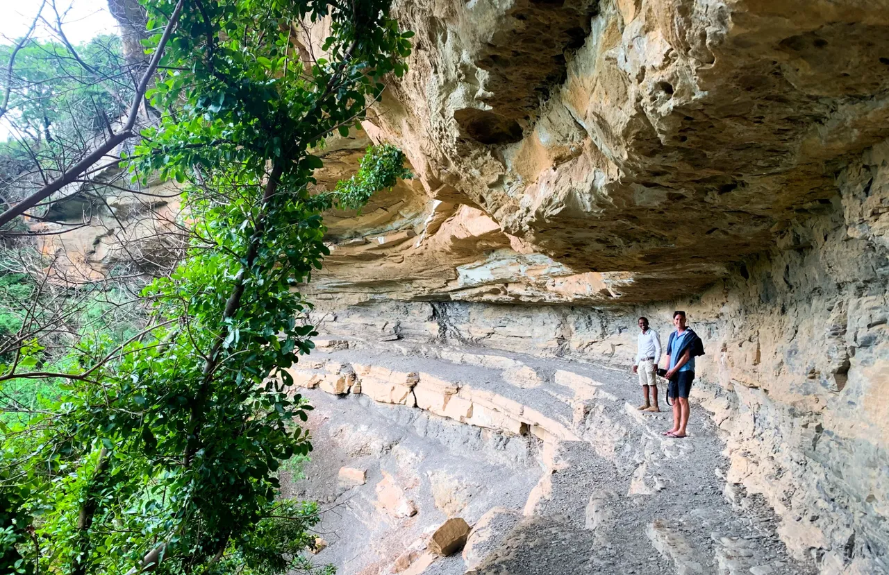 Dwarfed by the overhanging rock.